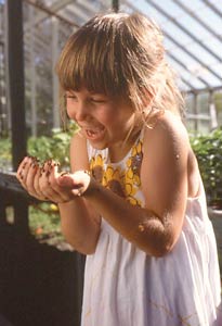 Involve children in gardening by having fun, like this little girl discovering lady beetles.